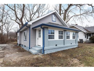 Newly renovated home with gray siding, blue accents and a landscaped yard at 3340 N Sherman Dr, Indianapolis, IN 46218
