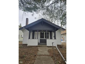 Charming bungalow with black and white exterior, front porch, and well-maintained landscaping at 4041 Boulevard Pl, Indianapolis, IN 46208