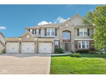Stunning two-story home with a three-car garage, stone accents, and a well-manicured lawn at 18725 Wychwood Pl, Noblesville, IN 46062