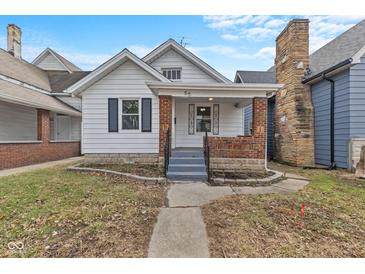Charming home with a walkway leading to a covered porch and brick accents at 55 E Regent St, Indianapolis, IN 46225