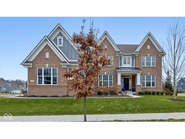 Charming two-story brick home with landscaped yard, beautiful lawn and blue trim accents at 6777 Pulaski Ct, Carmel, IN 46033