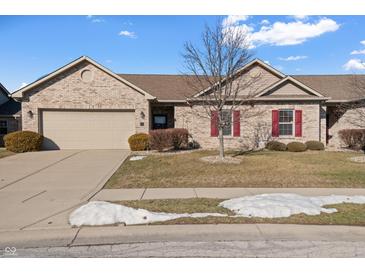 Brick ranch home with attached garage and landscaped lawn at 7710 Silver Moon Way, Indianapolis, IN 46259