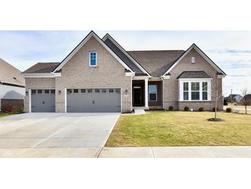 Two-story home with gray brick and a three-car garage at 11722 Platt St, Noblesville, IN 46060