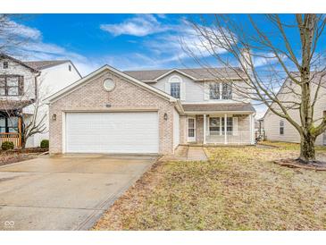 Charming two-story home features an attached garage, a welcoming front porch, and well-maintained landscaping at 1229 Tealpoint Cir, Indianapolis, IN 46229