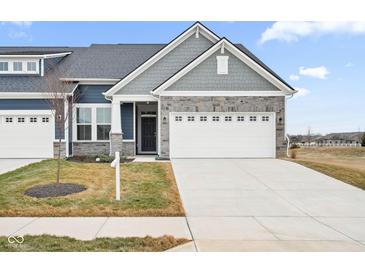 Gray exterior boasts a stone facade, two-car garage, and landscaping at 16930 Cole Evans Dr, Noblesville, IN 46060