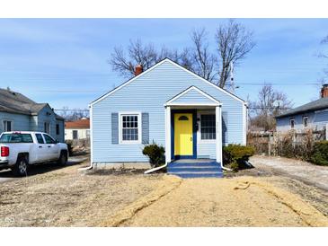 Charming light blue house with a bright yellow door, gray trim, and a small front yard at 3910 E 34Th St, Indianapolis, IN 46218