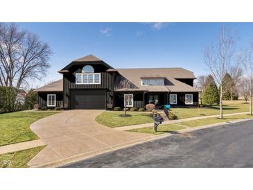 Stunning black two-story home with a well-manicured front yard and circular driveway at 11710 Cold Creek Ct, Zionsville, IN 46077