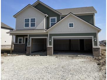 Two-story home featuring a two-car garage, varied siding, and brick facade accents at 8885 Lowell St, McCordsville, IN 46055