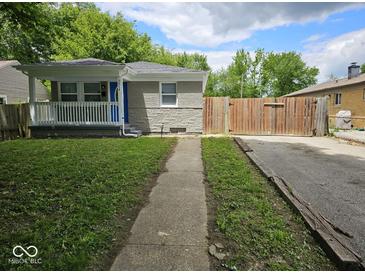 Charming home with a porch and a well-maintained front yard and long driveway at 2414 Walker Ave, Indianapolis, IN 46203