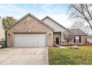 Charming brick and vinyl home with an attached two-car garage and well-maintained front yard at 12525 Wolford Dr, Fishers, IN 46038