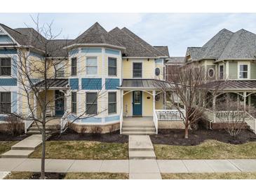 Charming yellow and blue townhouse with a covered front porch and well-maintained landscaping at 12755 Forsyth St, Carmel, IN 46032