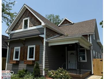 Charming gray two-story home featuring wood accents, shutters, flower boxes and a cozy front porch at 350 E Minnesota St, Indianapolis, IN 46225