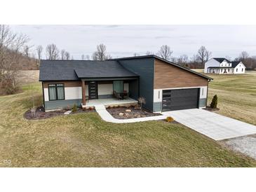 Stunning exterior view of a modern, single story home with a two-car garage and a spacious front yard at 5802 Watson Rd, Greenwood, IN 46143