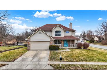 Charming two-story home features a covered porch, attached garage, and well-manicured lawn at 6530 Duck Pond Dr, Fishers, IN 46038