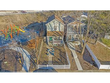 Charming home featuring an inviting front porch, a white picket fence and a nearby playground, perfect for Gathering enjoyment at 1515 Ringgold Ave, Indianapolis, IN 46203