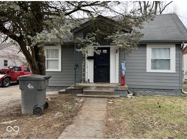Charming one-story home with a gray exterior, mature trees, and a welcoming front porch at 3306 N Drexel Ave, Indianapolis, IN 46218