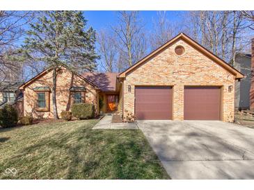 Charming brick home with an attached two-car garage and well-maintained landscaping at 8349 Tequista Cir, Indianapolis, IN 46236