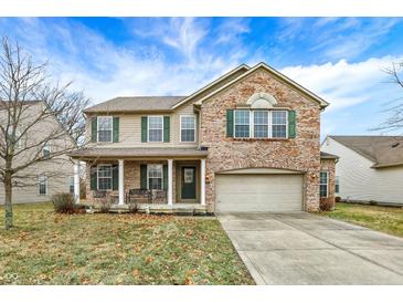 Charming two-story home with a brick and tan exterior, a covered front porch and well-manicured lawn at 1563 Old Thicket Ct, Greenwood, IN 46143