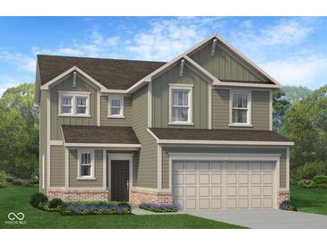 Charming two-story home with an attached two-car garage, brick accents, green siding and a well-manicured lawn with landscaping at 1934 Black Oak Dr, Shelbyville, IN 46176