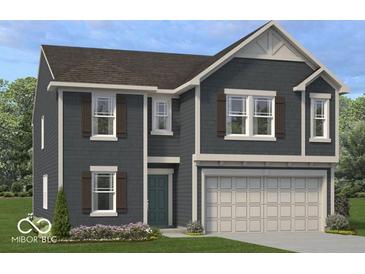 Charming two-story home features blue siding, shutters, a two car garage and a well manicured lawn at 1935 Black Oak Dr, Shelbyville, IN 46176