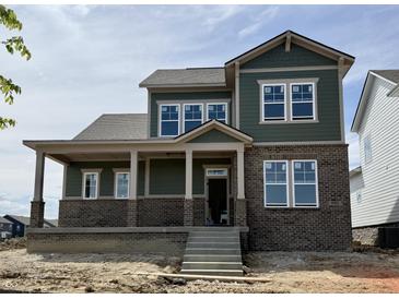 Two-story home with green siding, brick accents, covered porch, and multiple windows at 19997 Old Dock Rd, Westfield, IN 46074