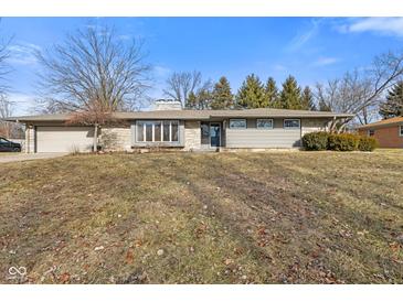 Charming single-story home featuring a stone facade, attached garage, and well-maintained front yard at 2016 Colt Rd, Indianapolis, IN 46227