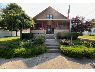Charming home featuring a covered porch, red columns, and a well-maintained front yard with mature trees and landscaping at 403 S Ohio St, Sheridan, IN 46069