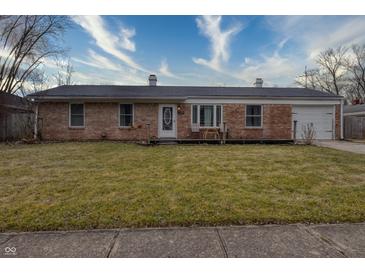 Brick ranch house with a spacious lawn, attached garage, and a front porch at 770 Berkley Dr, Fortville, IN 46040