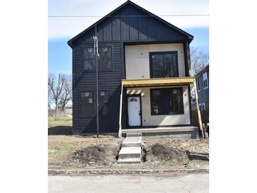 Modern two-story home featuring black siding, large windows, and a covered porch, in a construction phase at 1523 N Beville Ave, Indianapolis, IN 46201