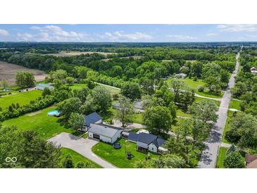 Lovely aerial shot of a charming farmhouse-style home surrounded by green pastures and trees at 4131 N County Road 500 E, Danville, IN 46122