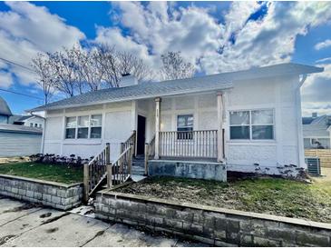 Charming home with a stucco exterior, inviting front porch, and well-maintained landscaping at 117 W 36Th St, Indianapolis, IN 46208