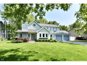 Charming two-story home with blue trim, attached garage, and lush green lawn at 11710 E 75Th St, Indianapolis, IN 46236