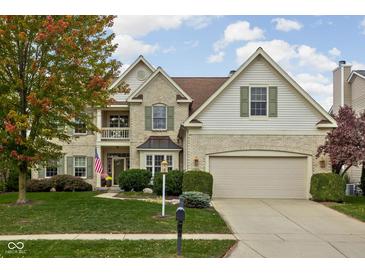 Charming two-story home with brick accents, lush lawn, green shutters, and attached two car garage at 12576 Mojave Dr, Fishers, IN 46037