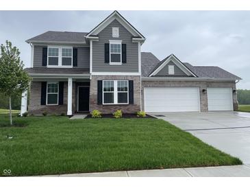 Charming two-story home with gray siding, brick accents, and a well-manicured lawn at 567 Hidden Hills Dr, Pittsboro, IN 46167
