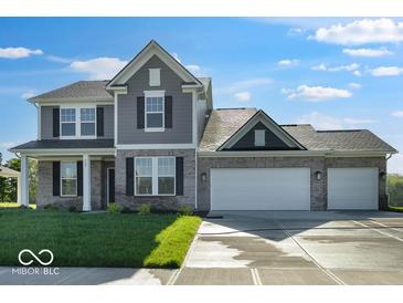 Charming two-story home with a brick and gray siding exterior and a spacious three car garage at 567 Hidden Hills Dr, Pittsboro, IN 46167