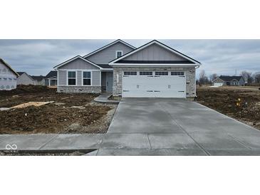New construction featuring stone accents, gray siding, and an attached two-car garage at 13862 N Americus Way, Camby, IN 46113