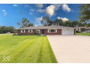 A charming single-story brick home with a well-manicured lawn and an extended driveway at 1002 Payton Ave, Indianapolis, IN 46219
