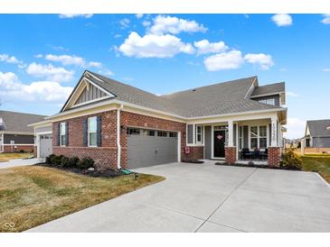 Charming brick home boasts a well-manicured lawn and inviting front porch, perfect for relaxation at 17330 Graley Pl, Westfield, IN 46074