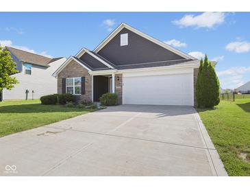 Charming home with a two-car garage, brick accents, and a well-maintained lawn and landscaping at 4236 Stubbington Ln, Indianapolis, IN 46239