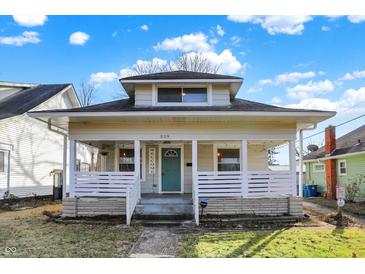 Charming home with a welcoming front porch, white railing, and a vibrant teal door, complemented by a well-kept lawn at 529 W 42Nd St, Indianapolis, IN 46208