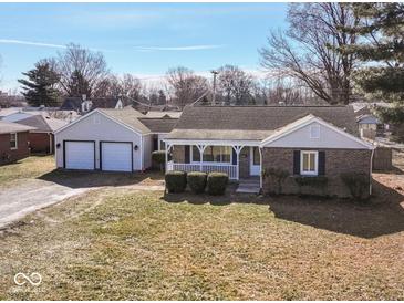 Charming single-story home with brick accents, a covered porch, and an attached two-car garage at 117 W Mckenzie Rd, Greenfield, IN 46140