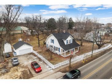 Charming two-story home featuring a gambrel roof, white siding, blue shutters, and a well-manicured lawn at 122 S Green St, Brownsburg, IN 46112