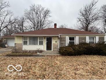 Modest single-story home featuring stone and siding with a muted landscape under an overcast sky at 5834 42Nd St, Indianapolis, IN 46226