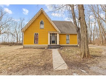 Charming yellow two-story home featuring unique architectural details and a well-maintained front yard at 6428 Bluff Crest Ct, Indianapolis, IN 46217