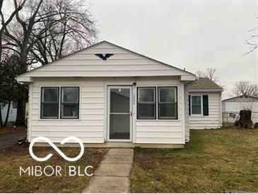 Charming single-story home features a tidy front yard and white siding at 1220 E Second St, Greenfield, IN 46140