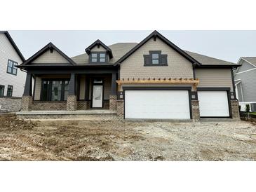 Charming two-story home featuring a brick-accented porch and a two-car garage at 19868 Chatham Shore Ln, Westfield, IN 46074