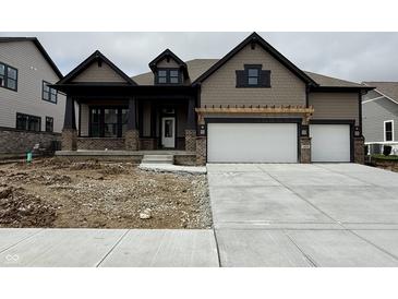 Two-story home featuring a two-car garage, covered porch, brick accents, and neutral colored siding at 19868 Chatham Shore Ln, Westfield, IN 46074