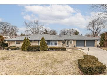 Charming single-story home with a stone facade, well-manicured shrubs, and a two-car garage at 2212 Albert St, Anderson, IN 46012