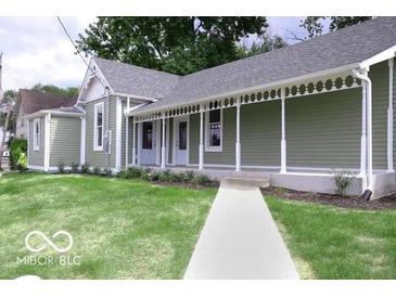 Charming single-story home showcasing a well-manicured lawn and inviting front porch at 621 W 10Th St, Indianapolis, IN 46202