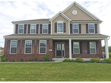 Charming two-story home with brick accents, black shutters, manicured lawn and inviting front porch at 7027 Pinnacle Dr, Columbus, IN 47201